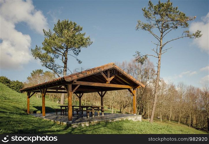 Wooden pavillion with picnic tables over nature background. Gazebo with picnic tables over nature background