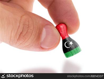 Wooden pawn with a painting of a flag, Libya