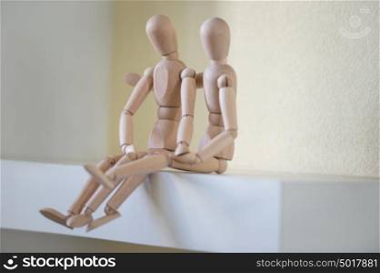 Wooden people sitting at home and hugging. People relationship concept
