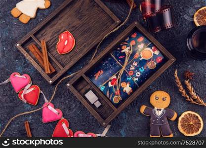 Wooden photo box with photo for Valentine&rsquo;s Day or Wedding Day. Decorated with gingerbreads. Romantic or love concept. Gingerbreads for Valentines Day on dark concrete background. Wooden photo box with photo for Valentine&rsquo;s Day or Wedding Day