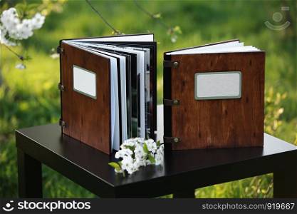 wooden photobook on the table. two wooden photo books on the table in the nature. place for the inscription