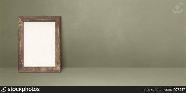 Wooden picture frame leaning on a grey wall. Blank mockup template. Horizontal banner. Wooden picture frame leaning on a grey wall. Horizontal banner