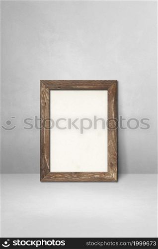 Wooden picture frame leaning on a light grey wall. Blank mockup template. Wooden picture frame leaning on a light grey wall