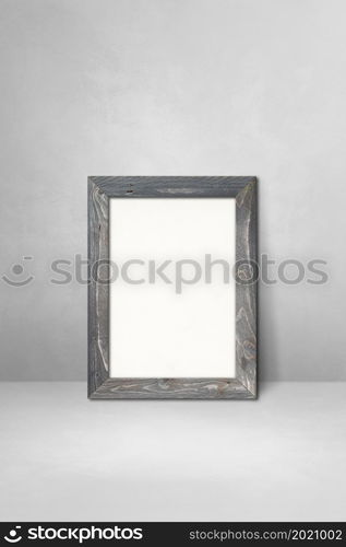 Wooden picture frame leaning on a light grey wall. Blank mockup template. Wooden picture frame leaning on a light grey wall