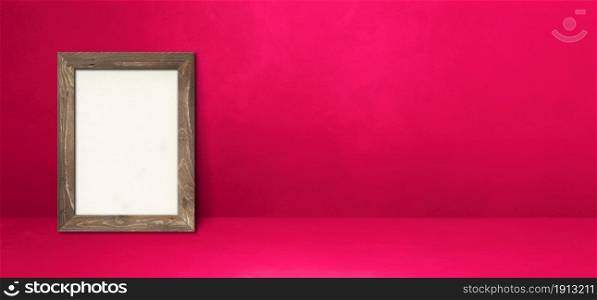 Wooden picture frame leaning on a pink wall. Blank mockup template. Horizontal banner. Wooden picture frame leaning on a pink wall. Horizontal banner