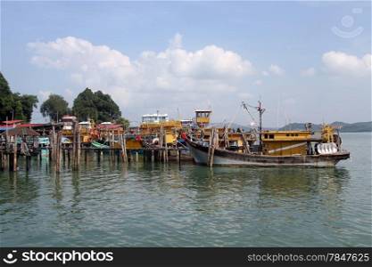 Wooden pier and fishing boats on the Pangkor island, Malaysia