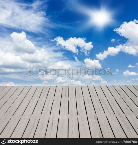 wooden pier and sky with white clouds. pier over clouds