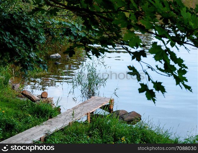 wooden pier from the planks near the river, made in the countryside. Wooden walkway near the river