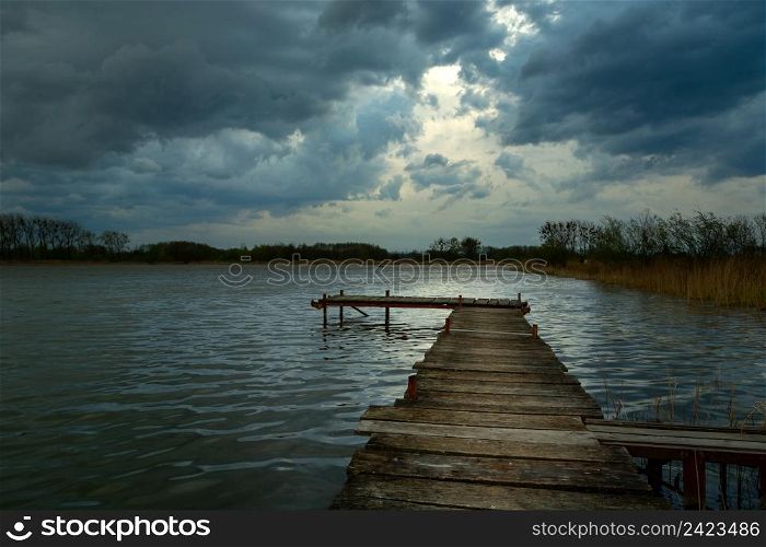 Wooden pier on a lake and dark clouds on the sky, Stankow, Lubelskie, Poland