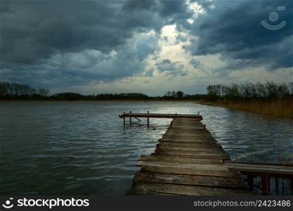 Wooden pier on a lake and dark clouds on the sky, Stankow, Lubelskie, Poland