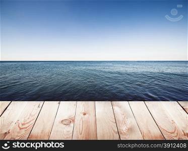 Wooden pier on blue sea and sky background