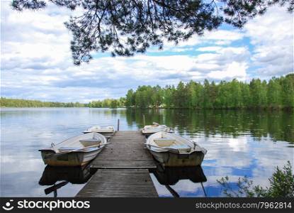 Wooden pier with moored rowing boats in a calm and peaceful bay