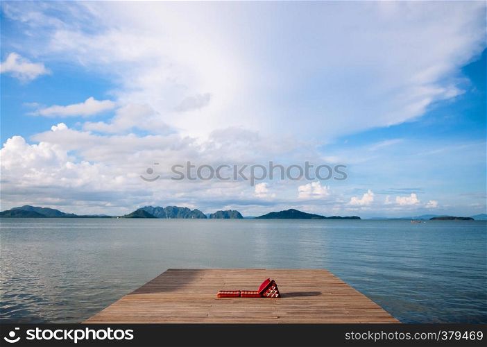 Wooden pier with Thai futon and triangle pillow, calmpeaceful andaman sea with islands view in summer at Koh lanta, Krabi, Thailand. Black and white image.