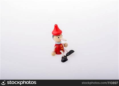 Wooden pinocchio doll with his long nose on a white background