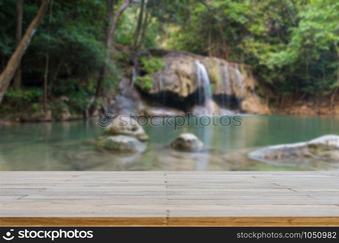 Wooden plank and background with Blur Waterfall Erawan Park