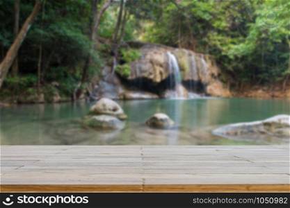 Wooden plank and background with Blur Waterfall Erawan Park