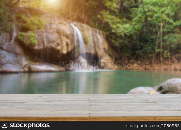 Wooden plank and background with Blur Waterfall Erawan Park