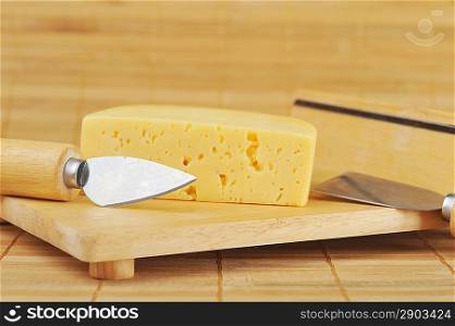 wooden plate and knives for cutting cheese. kitchenware