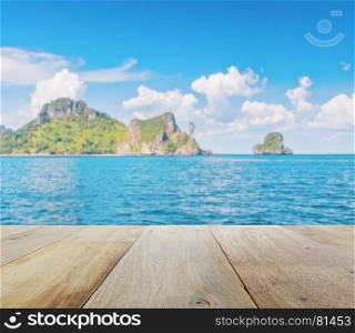 wooden platform with blurred beautiful seascape of chicken island (koh kai) in the andaman sea, off the coast of Krabi, Thailand