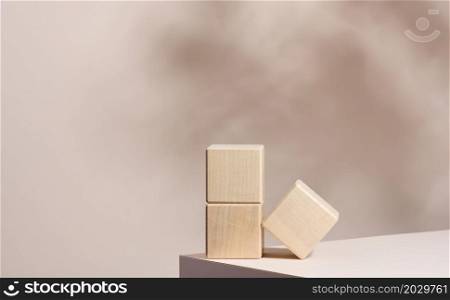 wooden podium to showcase cosmetics and other items, beige background with shadow