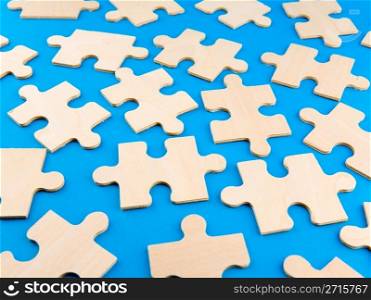 Wooden puzzle pieces on blue background
