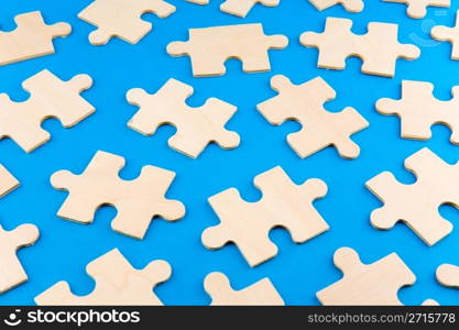 Wooden puzzle pieces on blue background