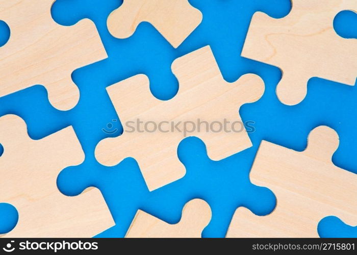 Wooden puzzle pieces on blue background