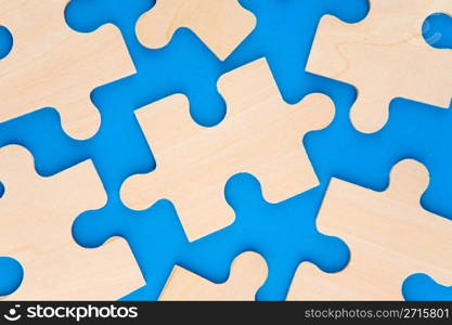 Wooden puzzle pieces on blue background