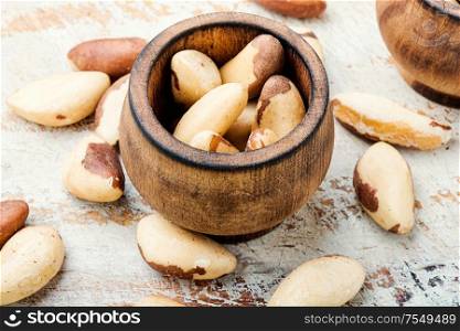 Wooden retro mortar filled with Brazil nut. Brazil nut or Bertholletia