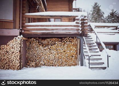 Wooden rural background. Stack of firewood on a background of a wooden wall.