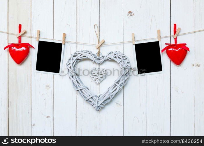 wooden rustic decorative hearts and photo frame hanging on vintage wooden background with space.