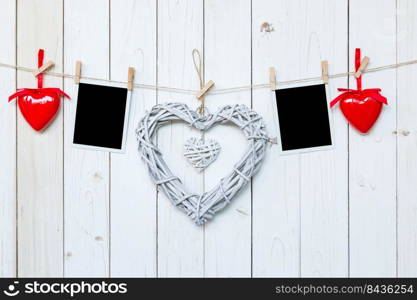 wooden rustic decorative hearts and photo frame hanging on vintage wooden background with space.