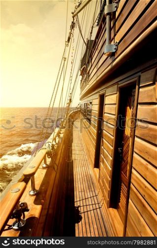 Wooden sailboat in sea at the bright sunrise