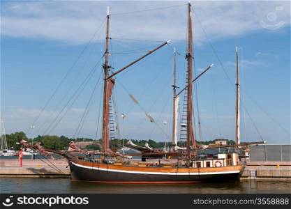 wooden sailing vessel in the port with a flat sail