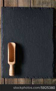 Wooden scoop on slate background