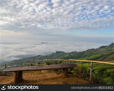 Wooden seat at mountain view point over sea of fog in Phetchabun, Thailand