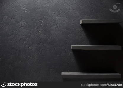 wooden shelf at black wall background