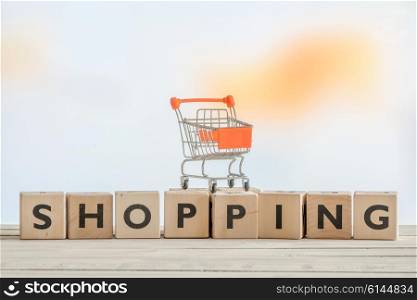 Wooden shopping sign with an orange cart