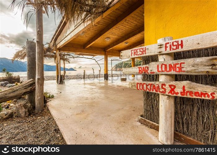 Wooden sign at beach bar on Bussaglia beach near Porto on west coast of Corsica