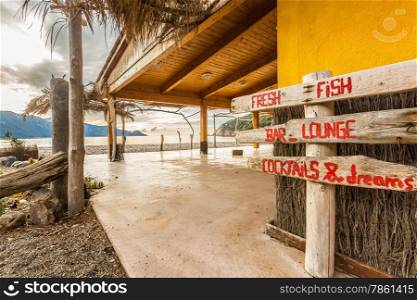 Wooden sign at beach bar on Bussaglia beach near Porto on west coast of Corsica
