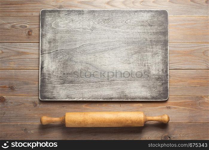 wooden sign board and rolling pin at rustic plank table background, top view