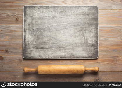 wooden sign board and rolling pin at rustic plank table background, top view