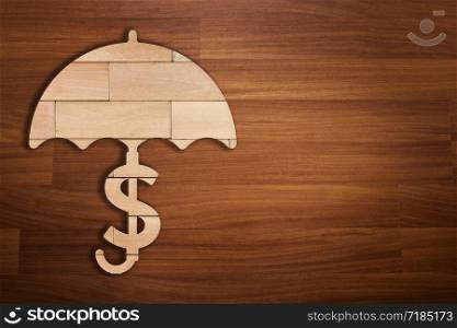 Wooden silhouette of dollar sign under umbrella