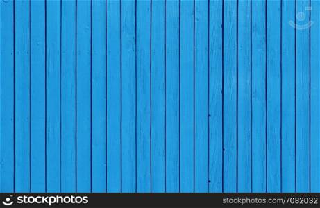 Wooden slat fence with parallel planks with blue paint.. Wooden fence with parallel planks with blue paint.