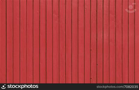 Wooden slat fence with parallel planks with red paint.. Wooden fence with parallel planks with red paint.