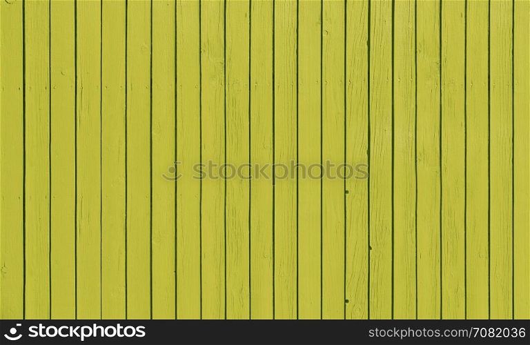 Wooden slat fence with parallel planks with yellow paint.. Wooden fence with parallel planks with yellow paint.