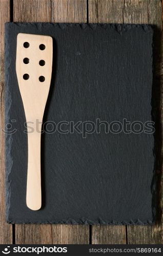 Wooden spatula on slate background