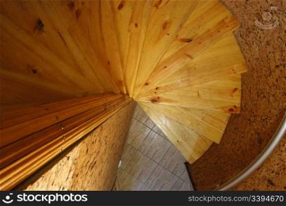 Wooden spiral staircase. An iron handrail, a steep slope