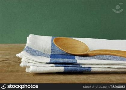 wooden spoon and dishcloth on old wooden table