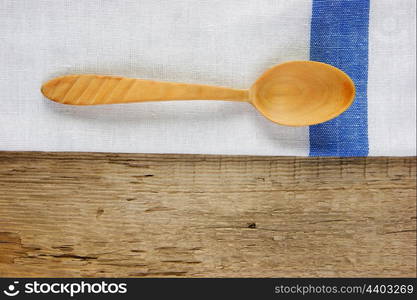 wooden spoon and dishcloth on old wooden table